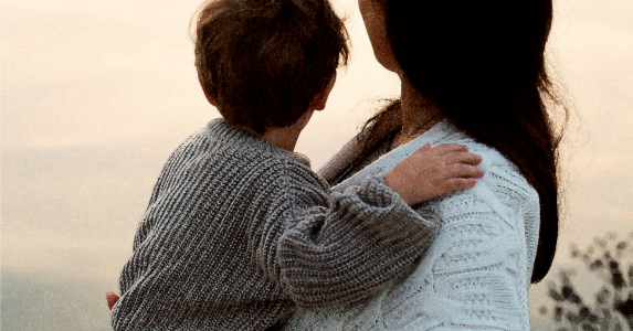 De dos une femme avec un enfant dans les bras 